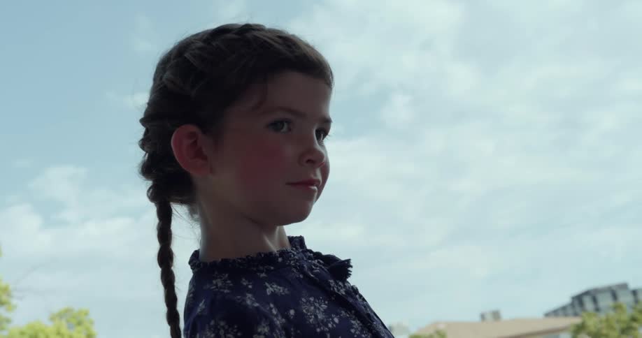 Man extends a hand to girl with braids and blue dress