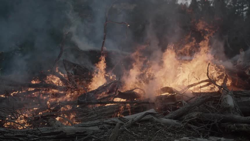 A fire burns giving off lots of smoke