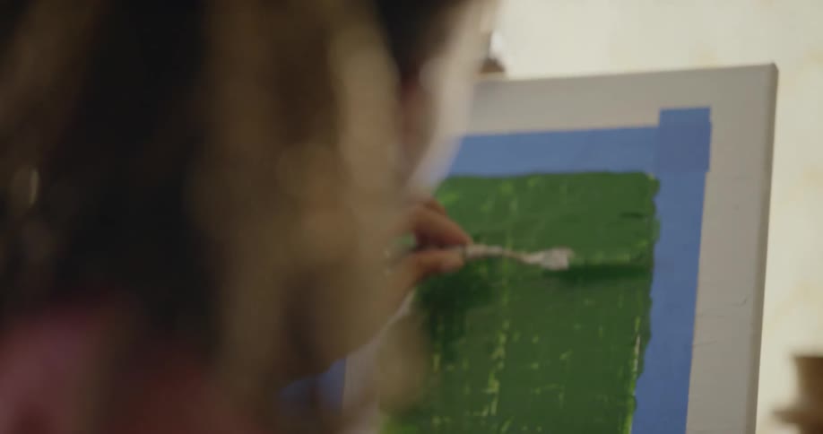 A woman paints on a canvas