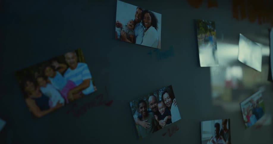 Photos of happy families taped to the wall on a dimly lit room