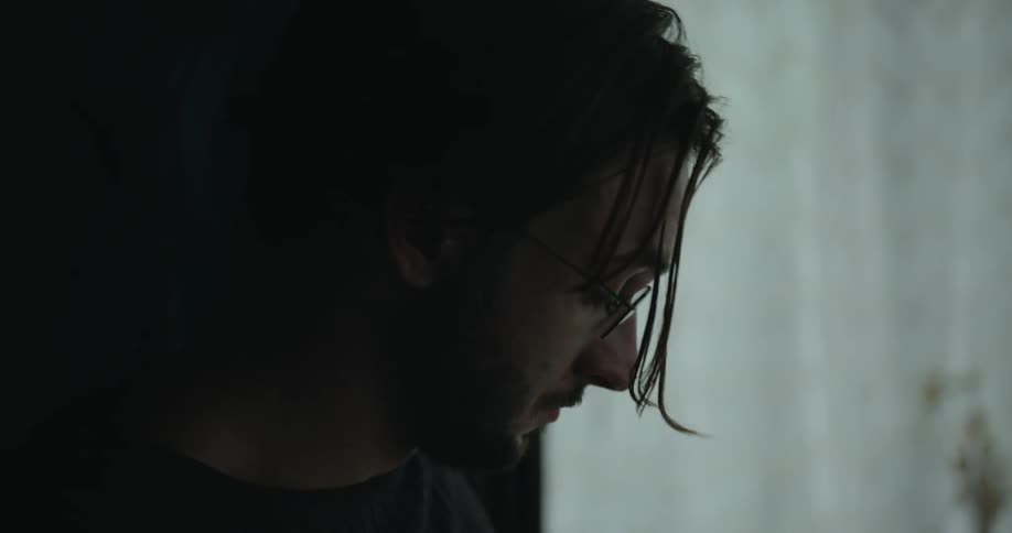 A man is peering out the window