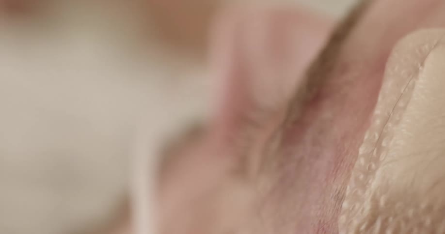 Close up of the face of an injured patient resting on a hospital bed