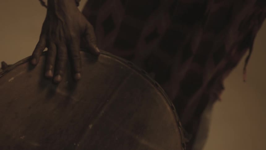 A man is beating a drum below