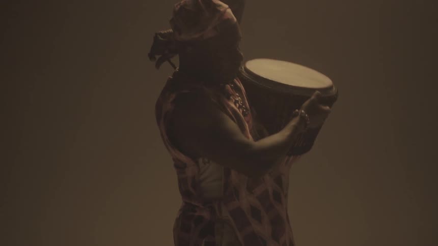 A man lifts a drum across his shoulder