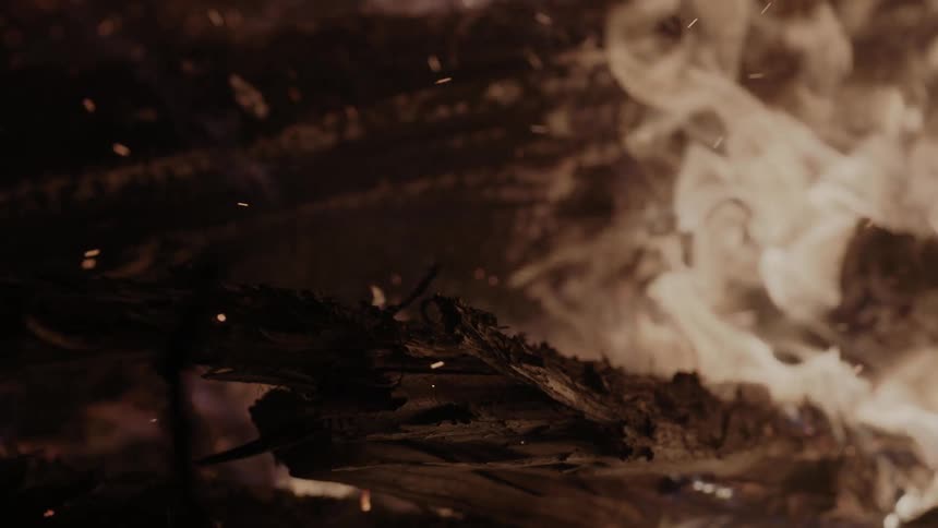 A fire burns giving off ash