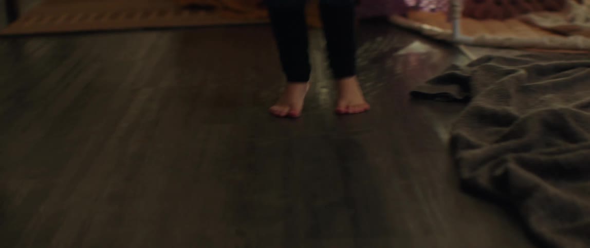 Young girls dance around and jump in their living room