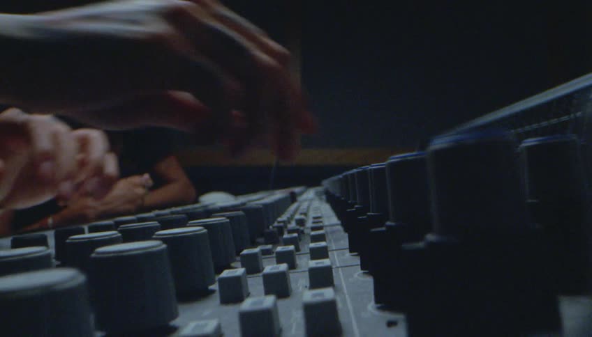 Male audio engineer mixes sound at cutting room recording studio