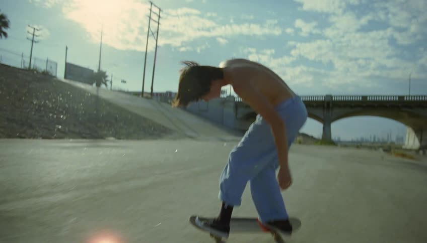 A boy on a skateboard does a jump and turns around