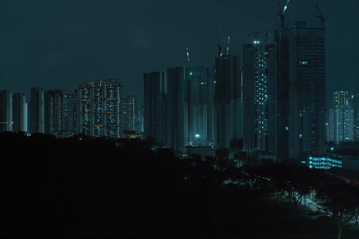 A futuristic city with towers and skyscrapers with matching lights is built and stands tall glowing in the night sky