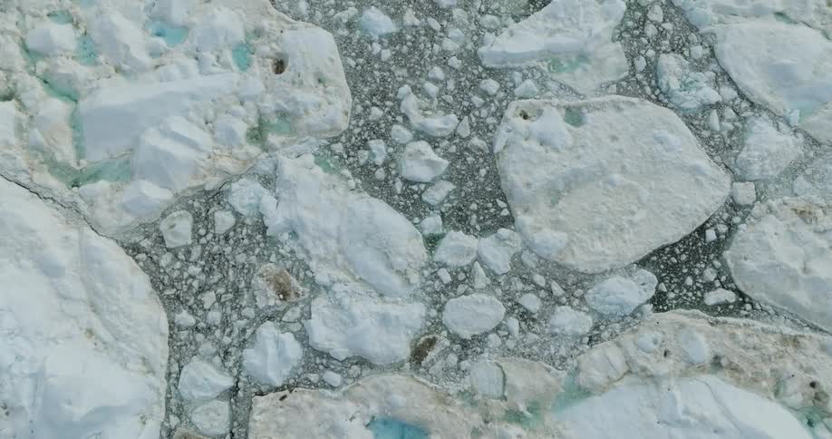 Aerial view of scattered pieces of floating ice and icebergs on the arctic ocean