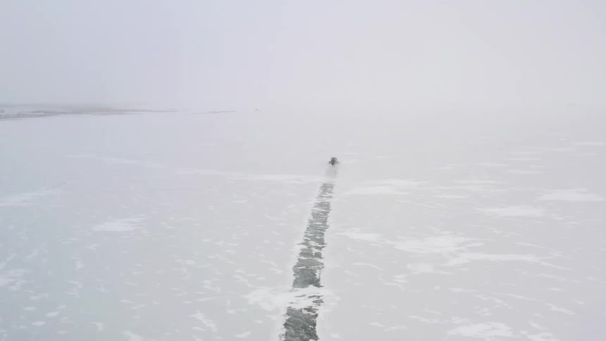 Aerial view of boat driving through ice floes