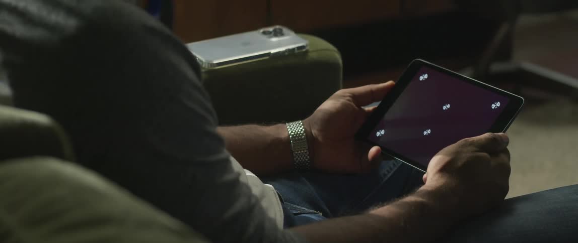A man sitting holding his tablet in both hands