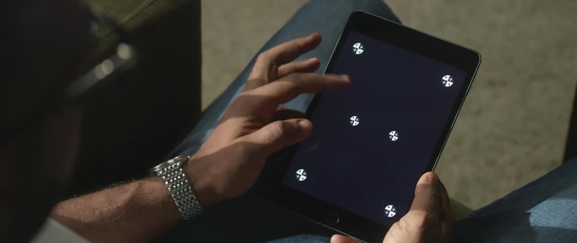 A young man is scrolling on a tablet in the middle of the day