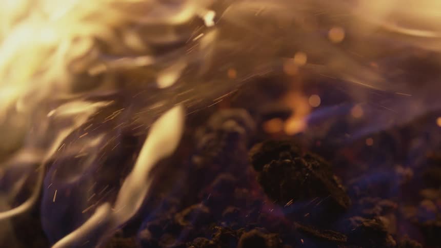 Fire rises off some coals