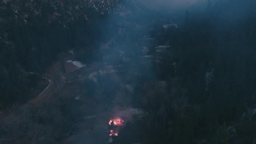 Smoke from a wildfire drifting over a wintry landscape