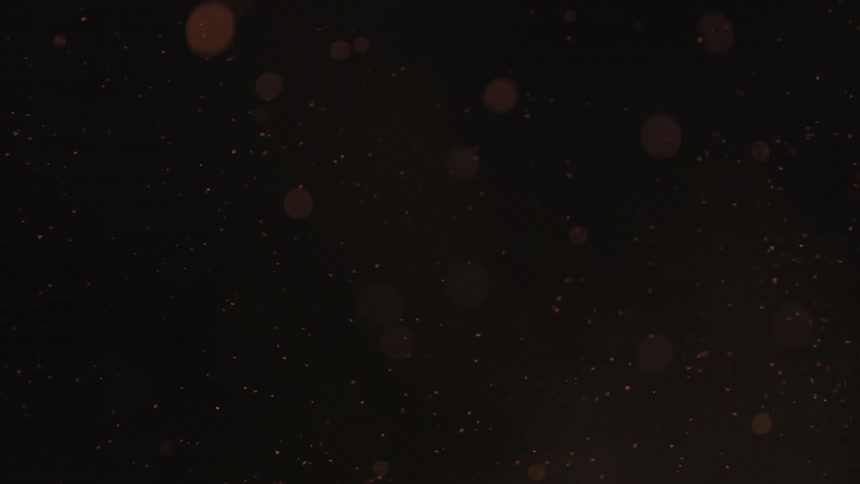 Burning embers floating up into the night sky