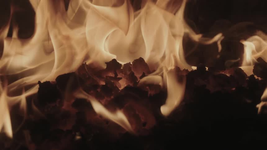 Flames burning over hot ashes