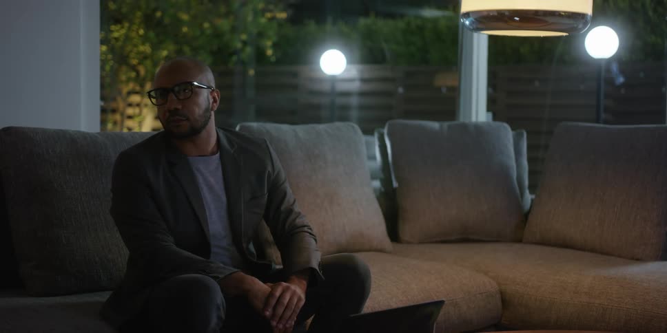A man getting up from sitting on a couch