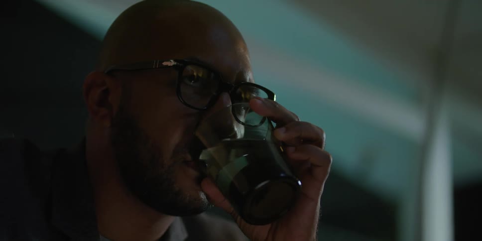 A man drinks from a glass of water