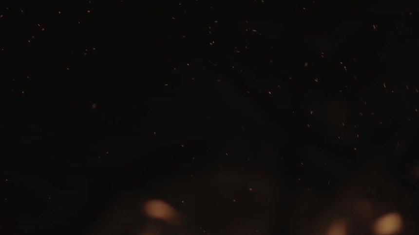 Sparks fly from a fire at night