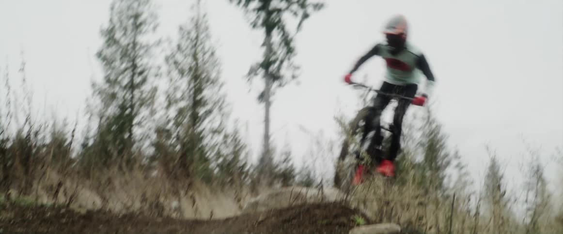 A person is jumping over hills on his mountain bike