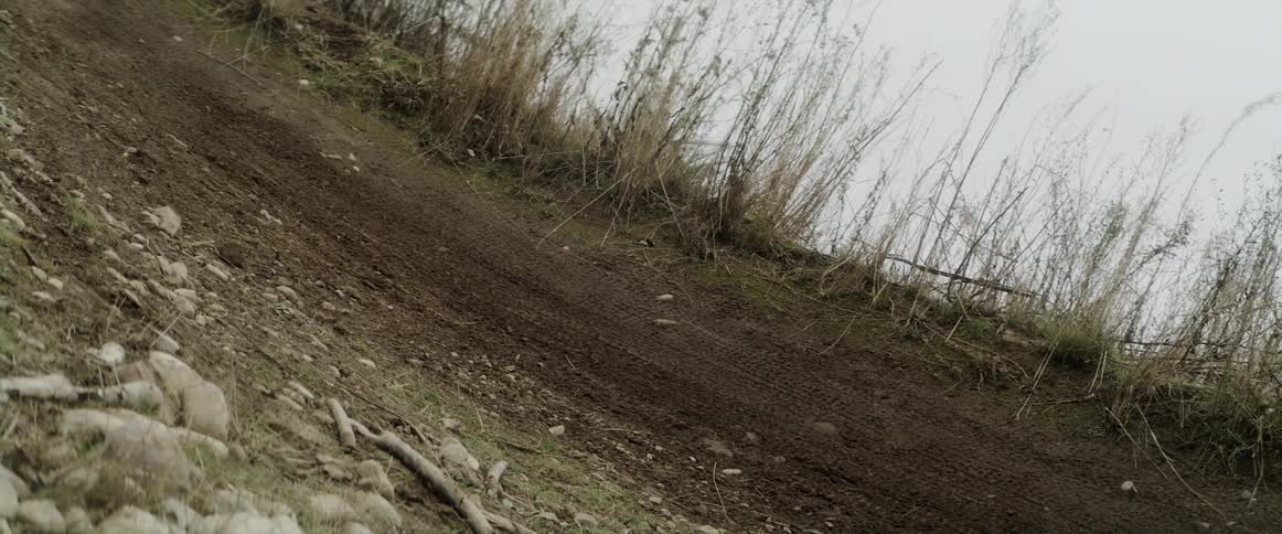 A cyclist rides in circles in a dirt path in a field