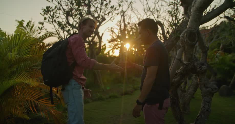 A man receives directions through a woodland from another man before the two men shake hands and part ways