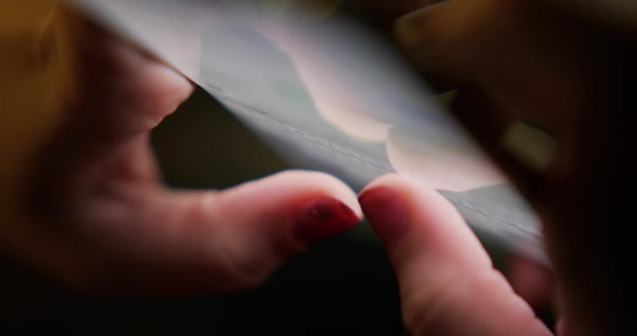 Close up of the fingers of a woman typing texting on a smartphone