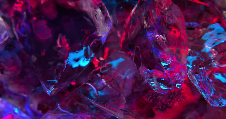 Ice cubes floating on liquid under shimmering blue and pink neon lights