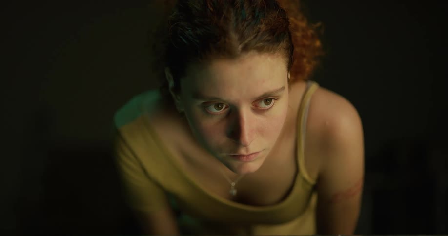 Redheaded woman blinks while staring