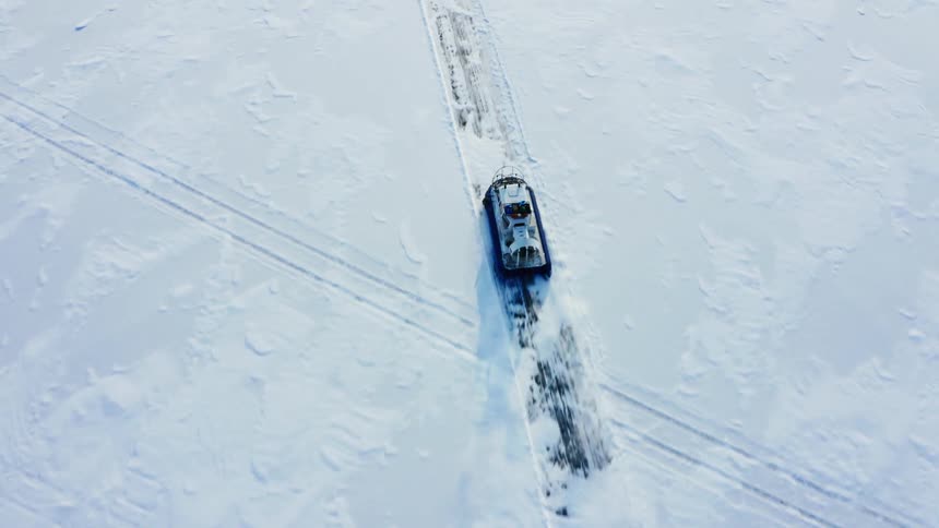 An airboat travels across the ice on a path in the snow