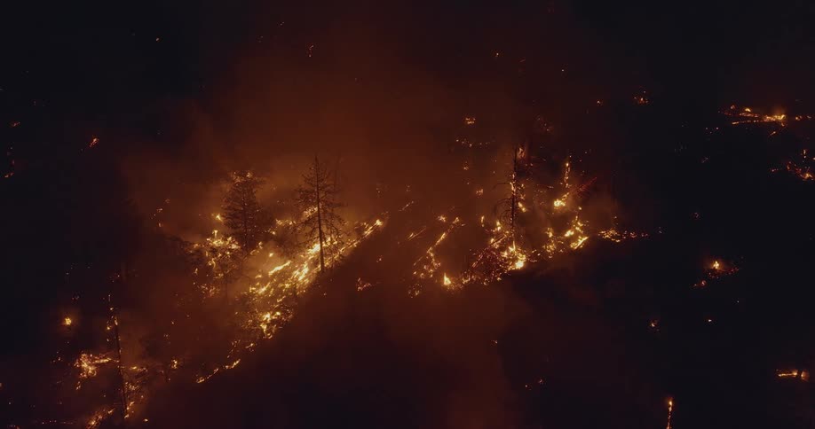 Aerial view of wildfire on the mountain slope at night
