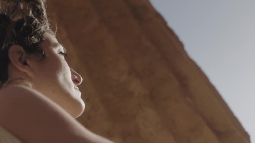 A woman looks up at a cloudy sky