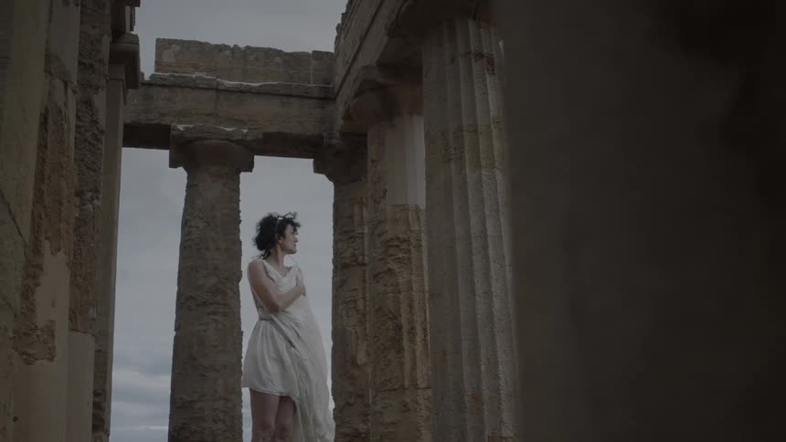 A woman standing in the acropolis on a windy, overcast day