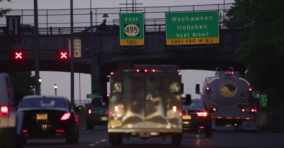 Vehicles are driving on a road while the sun is setting