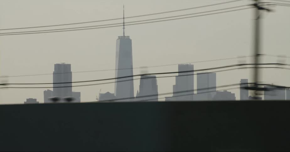 Silhouette of the skyscrapers in the new york city skyline seen from a moving vehicle at evening