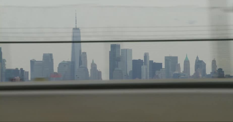 Highway traffic passes airport with skyline in the background
