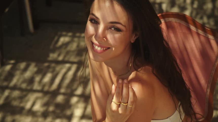 A model is posing while sitting in the chair