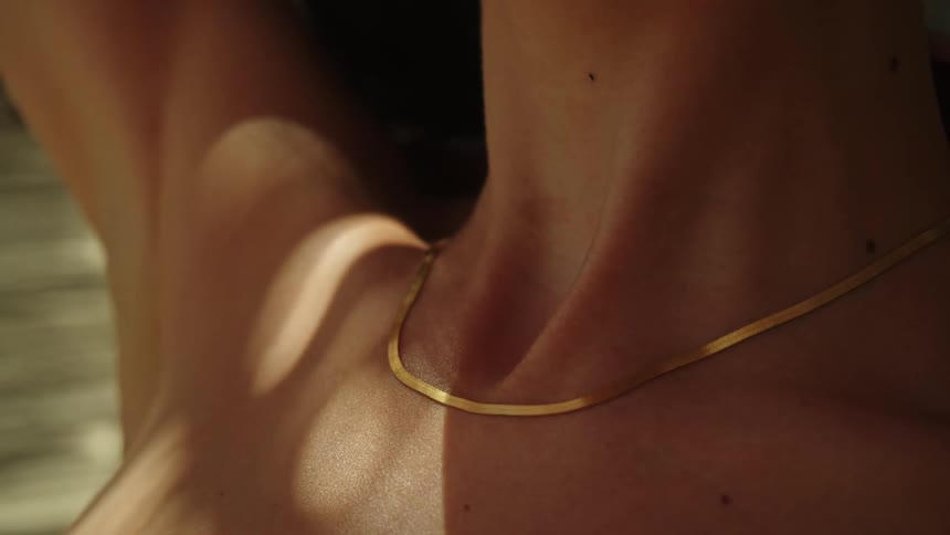 A woman wearing a gold chain necklace