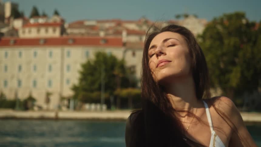 A woman is smiling outdoors during the day time