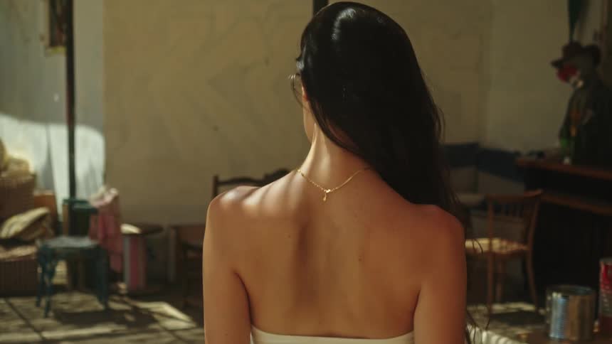 A woman is walking in a room during the day time