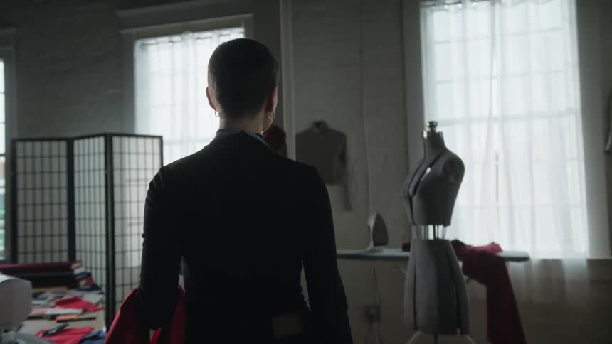 A woman walks towards the mannequin