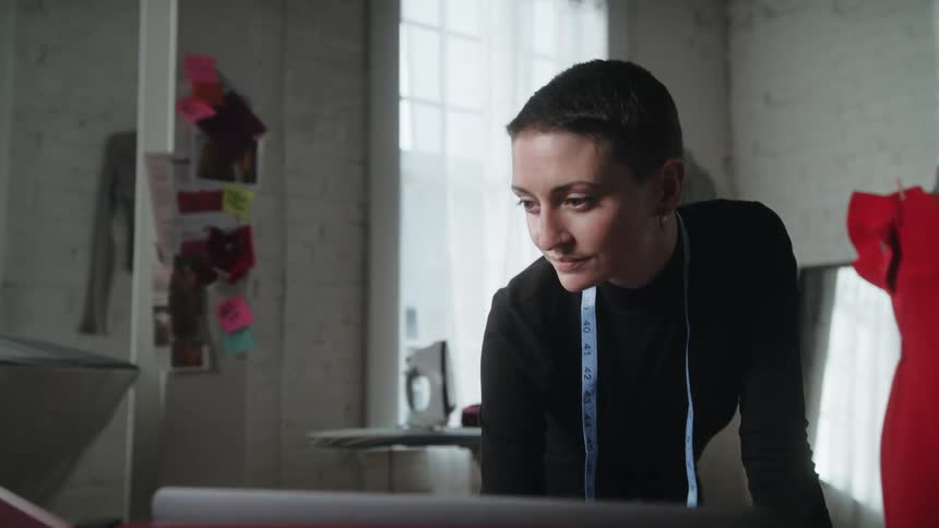A tailor is looking at a monitor