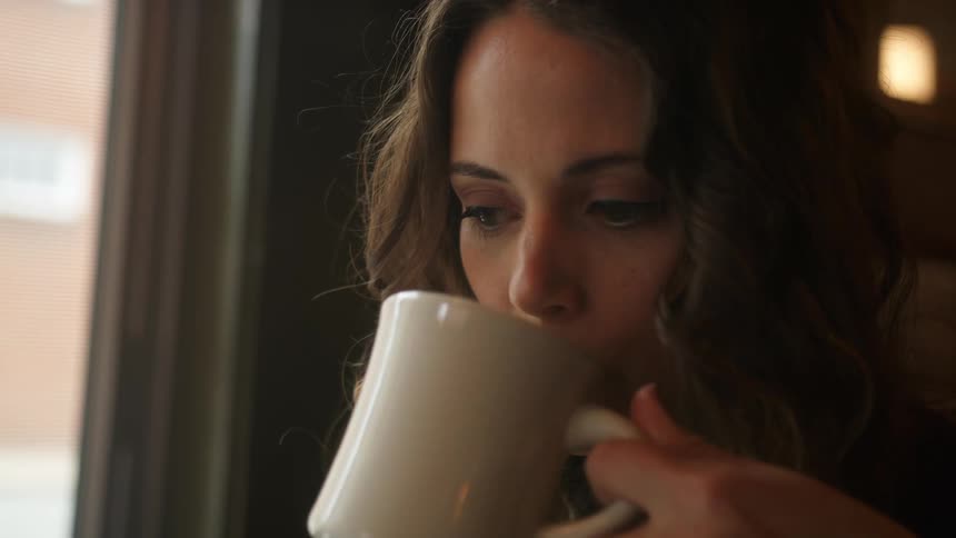 A woman drinks coffee