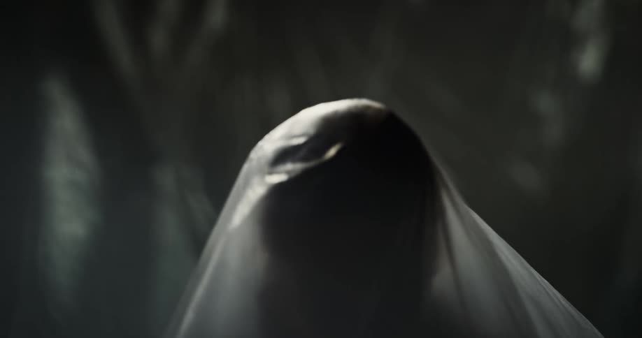 A woman moves slowly under the plastic sheet