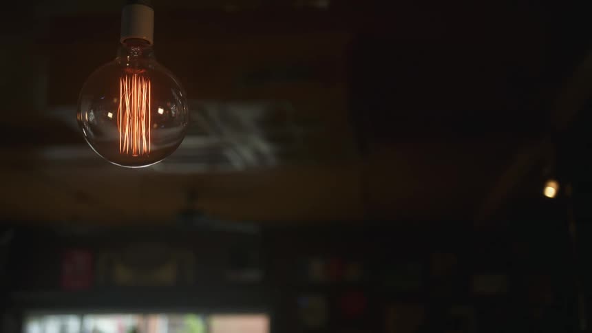 An old lightbulb is lit in the room