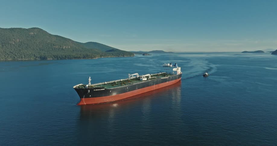 A barge pulls a smaller boat through the sea