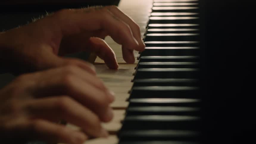 Close up of a mans hands as he plays piano