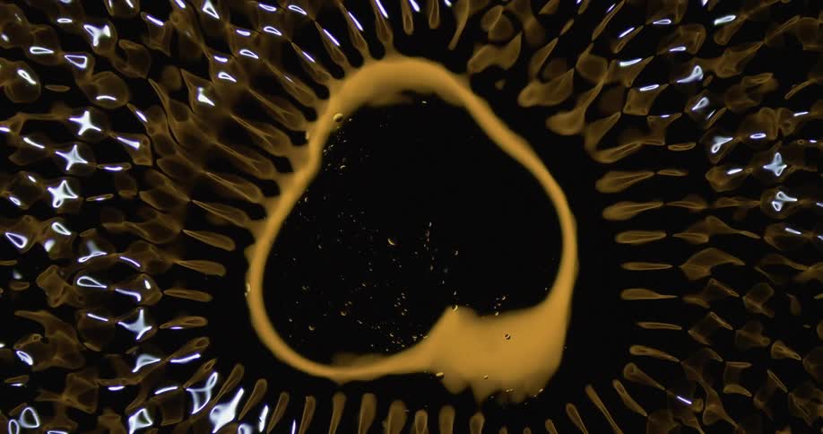 A round yellow shape reflects wildly on the rippling surface and rapidly vibrates and shapeshifts