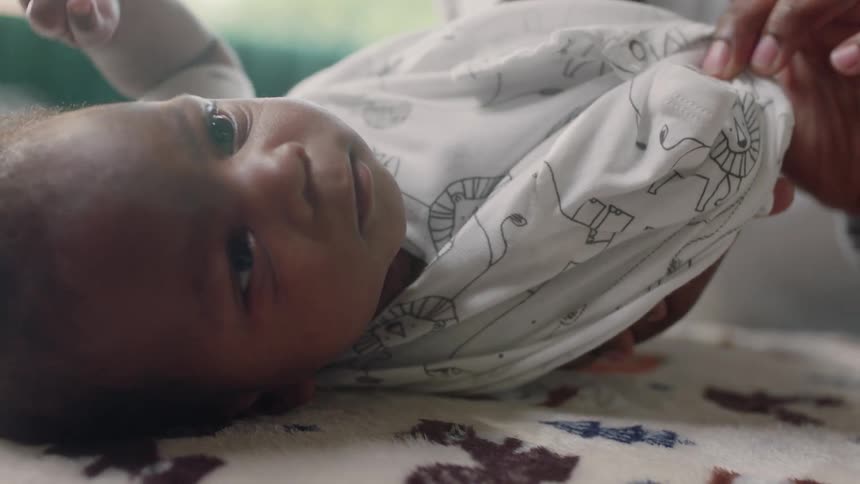Mother dresses newborn baby